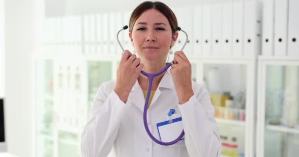 白いコートを着た自信のある女性医師が 診療所に立っている立体鏡を指さす 患者を受け入れる準備ができている心臓科医セラピスト — ストック動画