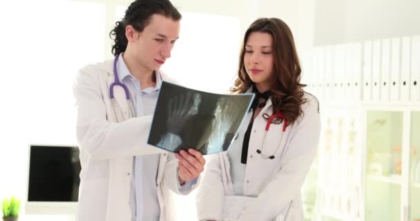 Dos Doctores Examinan Radiografía Una Pierna Rota Médico Apunta Radiografía — Vídeo de stock