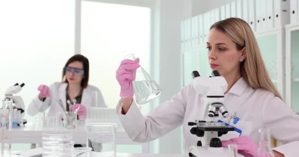Ученый Держит Фляжку Прозрачной Жидкостью Руках Лаборатории Внимательно Смотрит Проверка — стоковое видео