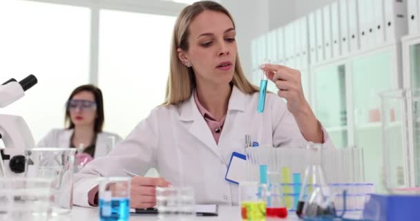Female Scientist Holds Test Tube Writes Chemical Data Obtained Scientific — Stock Video