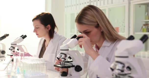 Jeunes Chercheuses Travaillant Ensemble Dans Laboratoire Clinique Examinent Échantillon Microscope — Video