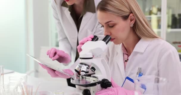 Deux Scientifiques Mènent Des Recherches Aide Microscope Une Tablette Numérique — Video