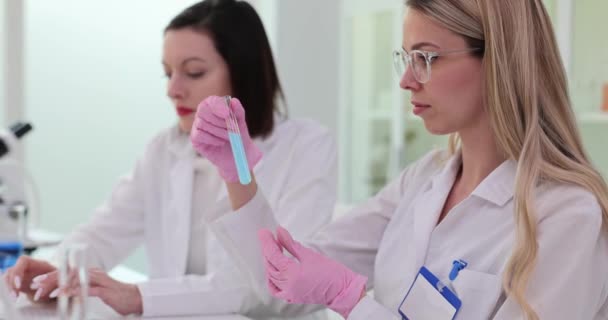 2人の女性科学者が実験室で働き 有毒な液体で試験管を保持している 科学医学近代研究所のチームワーク — ストック動画