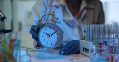 Doktor bilim adamı laboratuvarda çalar saati tutuyor. Modern keşiflerin ve yeniliklerin zamanı