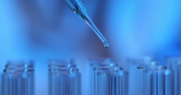 研究室で青い液体試験管で働く研究者 化学科学や医学生物学実験技術の概念 — ストック動画