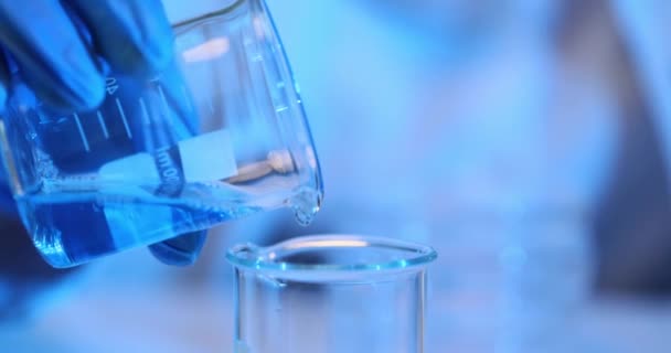 Wissenschaftler Mit Blauen Handschuhen Gießt Labor Vorsichtig Blaue Flüssigkeit Aus — Stockvideo