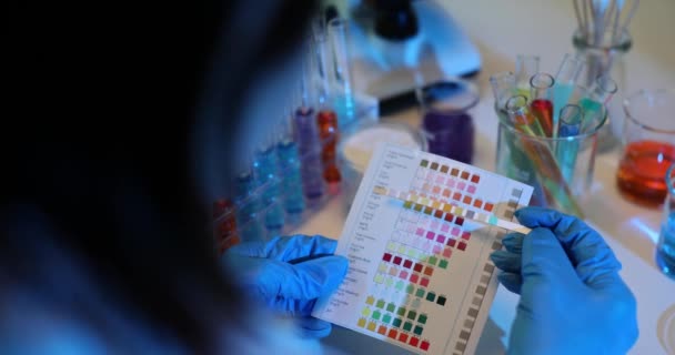 化学家在实验室里比较了色变石墨纸和色样 确定现代实验室化学溶液酸度的概念 — 图库视频影像