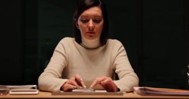 Odaklanmış kadın yönetici gece geç saatlerde ofiste bilgisayarla çalışıyor. Fazla mesai ve düzensiz çalışma saatleri