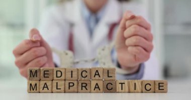 Tıbbi hata ve klinikte kelepçeli bir doktor. Kelepçeli doktor. Tıbbi ihmal ve hata kavramı.