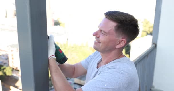 Mann Behandelt Balkonpfosten Aus Metall Mit Bohrmaschine Vor Rost Reparatur — Stockvideo
