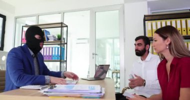 Kar maskeli banka müdürü güvenilir bir bankacılık reklamı yapıyor ve müşterilerle paralı iletişim kuruyor. Müşteri dolandırıcılığı ve finansal piramit