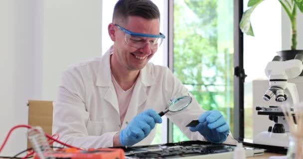 Sorrindo Engenheiro Bem Sucedido Olhando Para Chip Através Lupa Oficina — Vídeo de Stock