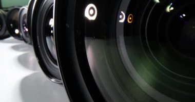 Karanlık arka planda görünür markaları olmayan kamera lensleri. Kamera için lens seçiliyor