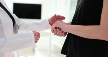 Doktor, klinikte hasta kadını tutuyor. Şefkatli destek ve tıbbi yardım