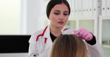 Trichology hastaların kafa derilerini büyüteç kullanarak inceliyor. Saç dökülme problemi
