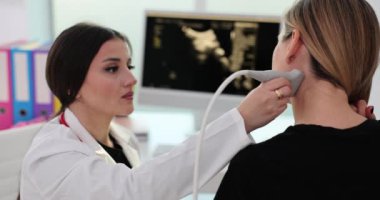 Doktor hasta boynunu incelemek için ultrason makinesi kullanıyor. Boyun damarlarının ultrasonu