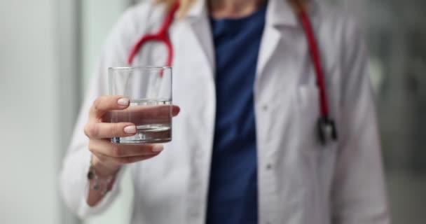 医者はきれいな健康な水のグラスを持っています 飲酒体制と健康と食事について — ストック動画