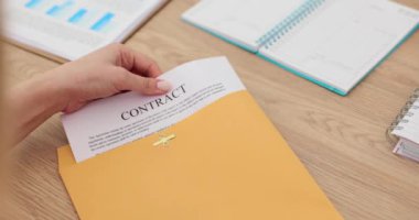 Kadın eller sarı bir zarf açar ve sözleşmeyi okur. Yönetici masadaki sözleşme belgelerini gözden geçiriyor.