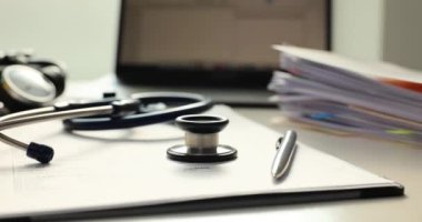 Steteskoplu doktor masası, kalem ve hasta tıbbi kayıtları. Tıbbi bakım veya eğitim