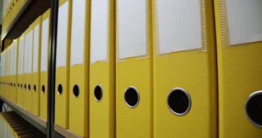 Ofiste sarı klasörlü sarı klasörler var. İş belgeleri ve arşiv