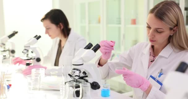 Två Kvinnliga Forskare Som Arbetar Ett Laboratorium Droppar Vätska Glas — Stockvideo