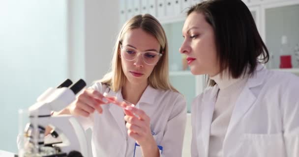 Две Женщины Учёные Исследуют Пробирку Красной Жидкостью Сотрудничество Химической Фармацевтической — стоковое видео