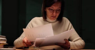 Ofis çalışanı karanlık bir ofiste otururken not alır. Gece işi ve fazla mesai