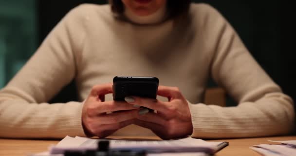 女性労働者は オフィスに座っているスマートフォンでボーイフレンドにメッセージを送ります 女性は仕事の課題について話すパートナーとコミュニケーション — ストック動画