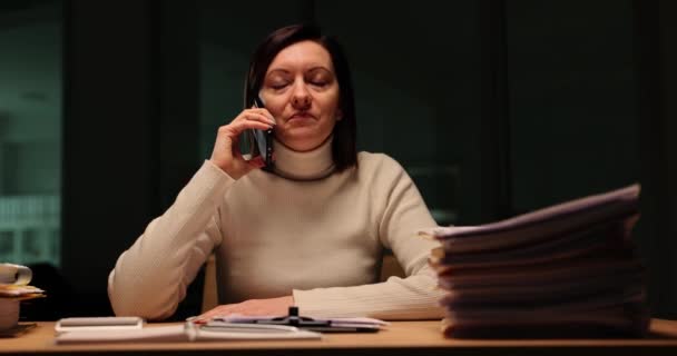 疲れた女性は 厳格なボスのスローモーションで話す電話に応答します 執筆された女性は オフィスで夕方に指示をマスターするためにリストします — ストック動画