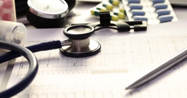 Mesa Médico Cheia Comprimidos Cardiograma Estetoscópio Demonstração Elementos Diagnósticos Terapêuticos — Vídeo de Stock