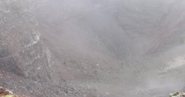 Yoğun sisle kaplanmış sisli dağ kraterinin çevresi. Çorak yamaçlar ve kayalık arazi jeolojik süreçlerin gücünü çağrıştırıyor.