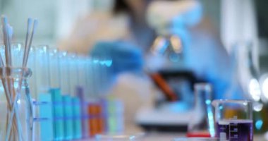 Bilim adamı laboratuvarda sıvı ile bir deney yapıyor. Laboratuvarda kırmızı turuncu sıvıyla test tüpü