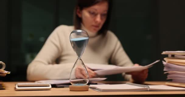 Ofiste Gece Geç Saatlerde Masasında Kum Saatiyle Çalışan Bir Kadın — Stok video