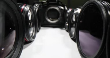 Beyaz arka planda bir kamera lensinin sinematik yakın çekimi. En önemli özellikler ve fonksiyonlar bir lens seçiyor