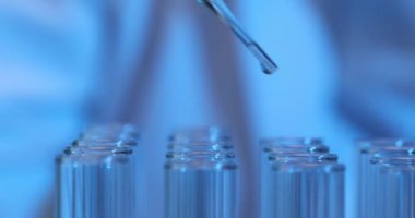 Laboratuvarda bir pipetten test tüpüne düşen bir sıvı damlası. Laboratuvarda bilimsel veya tıbbi laboratuvar araştırma tüpü