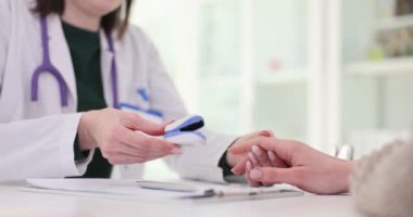 Doktor ve hasta nabız oksimetresini kullanarak nabzı ölçüyorlar. Kılcal kan oksijen doygunluğunun zararsız ölçümleri için tıbbi izleme ve tanı aygıtı