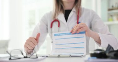 Sağlık sigortası başvurusu için doktor onayı. Onaylı terapist ve sigorta formu tutuyor.