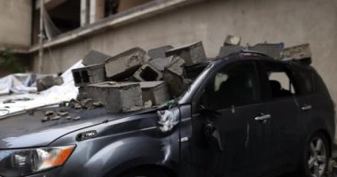 Çakıl taşları ve kayalar araba çöplüğündeki çökmüş otomobillerin üzerini örtüyor. Büyük taşlar hasarlı aracın çatısını kirletiyor. Düz olmayan bir yüzey oluşturuyor.