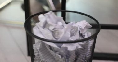 Ofis çalışanı buruşuk kağıtları çöp kutusuna atıyor. Çalışan belgeyi çökertir ve atık temizleme çalışma alanını yavaş çekimde imha eder