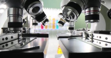 Mikroskop mercekleri numunelerin incelenmesi için hazır. Bilimsel araştırmalar için çağdaş araçlar laboratuvarda ağır çekimde duruyor