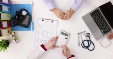 Doktor ve hasta tıbbi harcamaları tartışıyor. Tıbbi tedavi ve sigorta maliyeti