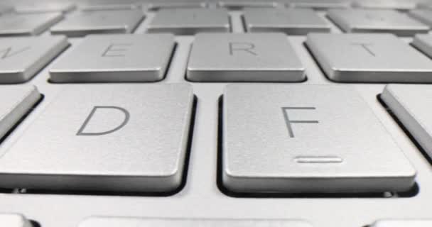 柔らかい光の下で現代のラップトップの光沢のキーボード 行の遅い動きで配置された文字とシンボルを持つキーボードのキー — ストック動画