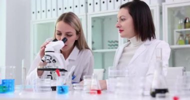 İki bilim adamı laboratuvarda mikroskopta yeni bir element keşfetti. Bilim adamlarından oluşan bir ekip ortak bilimsel araştırmayı tartışıyor