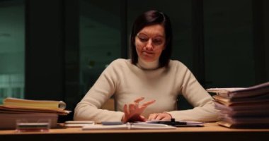 Stresli iş kadını gece geç saatlere kadar ofiste çalışıyor ve telefon bekliyor. Sinir bozucu müdür gece geç saatlerde iş yerinde telefona bakıyor.