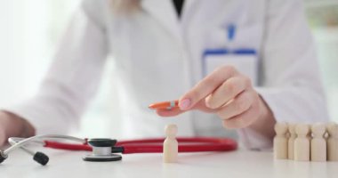 Doktor ahşap figürlere can simidi yerleştiriyor. Sağlık sigortası ve sağlık koruması