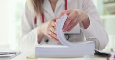 Doktor klinikte bir yığın dokümana göz atıyor. Tıbbi belgeler ve bürokrasi