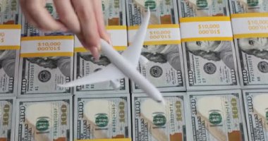 Yüz dolarlık banknotların üzerinde model uçak. Uçak biletleri için bilet ve fiyat artıyor