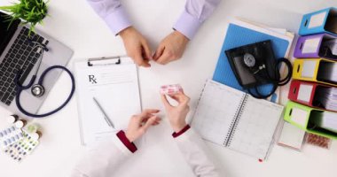 Cardiologist and patient discuss medications in clinic, top view. Painkillers for joint pain