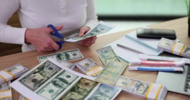 Kadın 100 dolar kesiyor. Kağıttan Amerikan banknotları