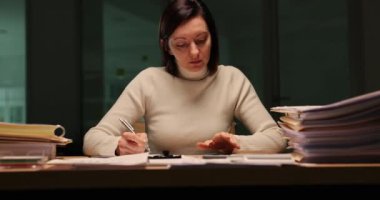 Yorgun ofis çalışanı akşam ofisinde evrak işleriyle çok meşgul. Gece geç saatlere kadar çalışmak ve tükenmek